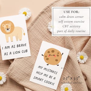 May include: Cards with illustrations and text. One card has a lion and the text "I AM AS BRAVE AS A LION CUB." Another card has a cookie and the text "MY MISTAKES HELP ME BE A SMART COOKIE." A third card lists uses: calm down corner, self esteem exercise, CBT activity, and part of daily routine. Each card is 2.5" x 3.5".