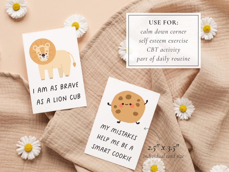 May include: Cards with illustrations and text. One card has a lion and the text "I AM AS BRAVE AS A LION CUB." Another card has a cookie and the text "MY MISTAKES HELP ME BE A SMART COOKIE." A third card lists uses: calm down corner, self esteem exercise, CBT activity, and part of daily routine. Each card is 2.5" x 3.5".