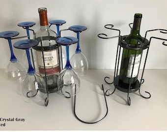 May include: Two black metal wine bottle and glass holders. The holder on the left has six glass holders and a bottle holder. The holder on the right has six glass holders and a bottle holder. Both holders have a black base and a black metal frame. The holder on the left has a bottle of wine in it. The holder on the right has a bottle of wine in it. The text "Color: Crystal Gray Patented" is visible at the bottom of the image.