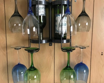 May include: A wall-mounted wine rack with two bottles of wine and eight wine glasses. The rack is made of metal and has a crystal gray finish. The glasses are a mix of blue, green, and clear glass. The rack is labeled "Patented".