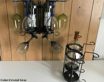 May include: A black metal wine rack with two bottles of wine and six wine glasses. The rack is mounted on a wall. There is also a black metal wine bottle holder with a single bottle of wine. The text "Color: Crystal Gray Patented" is visible in the image.