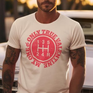 以下が含まれることがあります： 「My Only True Valentine」というテキストと、赤い車のギアシフトのグラフィックが描かれた白いTシャツ。