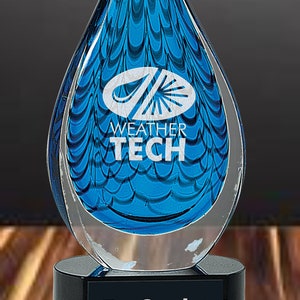 May include: A blue glass award in the shape of a teardrop with a white logo that says "Weather Tech" and the text "Top Service Provider" on a black base.