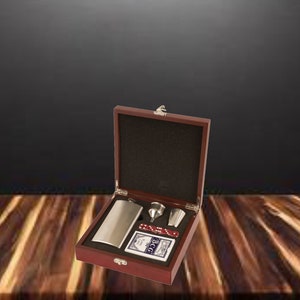 May include: A wooden box with a hinged lid, containing a stainless steel flask, a funnel, a shot glass, and a deck of playing cards. The box is closed and sitting on a wooden surface.