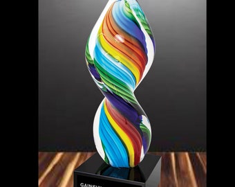 May include: A colorful glass sculpture award with a black base. The base has the text "Gainesville Art Show Best in Show".