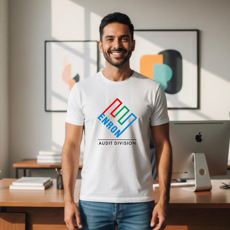 May include: White t-shirt with a colorful logo that reads "ENRON AUDIT DIVISION." The logo is a square design with red, green, and blue lines. The shirt is worn by a person.