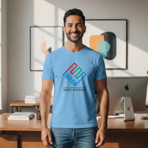 May include: A light blue t-shirt with the word "ENRON" in a red, green, and blue logo, with "AUDIT DIVISION" below. The shirt is worn by a person.