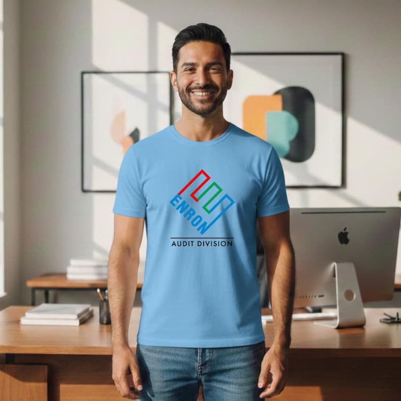 May include: A light blue t-shirt with the word "ENRON" in a red, green, and blue logo, with "AUDIT DIVISION" below. The shirt is worn by a person.