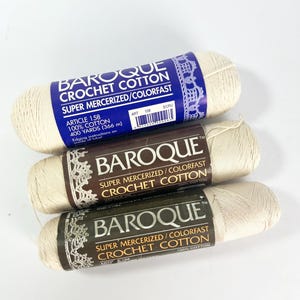 May include: Three spools of Baroque Crochet Cotton in cream color. Each spool has a label with the brand name, product details, and the words "Super Mercerized/Colorfast Crochet Cotton". The labels are in dark blue, brown, and dark green.