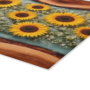 Peut inclure: Une planche en bois rectangulaire aux bords naturels int&eacute;grant une section centrale en r&eacute;sine transparente. La r&eacute;sine contient plusieurs tournesols jaune vif aux c&oelig;urs brun fonc&eacute; et de petites fleurs blanches incrust&eacute;es.