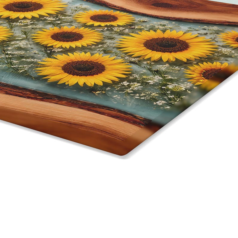 Peut inclure: Une planche rectangulaire pr&eacute;sentant un panneau central en r&eacute;sine transparente incrust&eacute; de tournesols jaune vif et de petites fleurs blanches, encadr&eacute; par deux bandes de bois naturel au grain visible et aux bords brun fonc&eacute;.