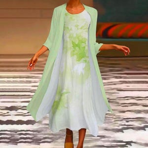 Peut inclure: Une robe midi sans manches avec un imprimé de feuilles botaniques blanc et vert clair, associée à un gilet assorti vert clair à manches longues et ouvert sur le devant. L'ensemble est composé d'un tissu léger et fluide à la coupe ample.
