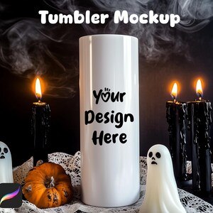May include: A white tumbler mockup with the text "Your Design Here" is the focal point of this Halloween-themed image. Black candles with dripping wax and lit flames flank the tumbler. A small pumpkin and ghost figures complete the spooky scene.