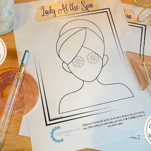 Op de afbeelding: Een printbaar knutselpatroon voor een "Lady At The Spa" ontwerp. Het patroon toont een vrouw met een handdoek op haar hoofd en komkommerplakjes over haar ogen. De tekst "Hobby and Commercial License. Do not sell or distribute this pattern in any way when posting on social media, you must credit Chantilly Lace as the pattern owner." is op de pagina opgenomen.