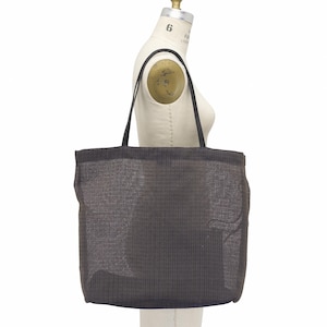 May include: A dark gray tote bag with black handles is displayed on a mannequin. The bag has a woven texture and a rectangular shape. The handles are thin and appear to be made of leather.