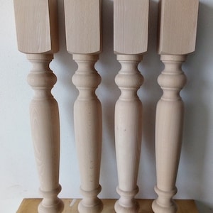 Peut inclure: Quatre pieds de table en bois non finis avec un design tourné. Les pieds mesurent environ 46 cm de haut et ont un dessus carré.
