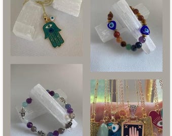 Puede incluir: Una colección de collares y pulseras de oro con el amuleto de la mano de Hamsa con un diseño de ojo turco. Algunas de las piezas están hechas con piedras preciosas de colores.