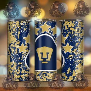 May include: A blue and gold tumbler with a white splatter pattern. The tumbler features a stylized puma head with five stars in the background.