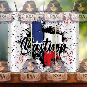May include: A white tumbler with a red, white, and blue Texas state outline and the word "Wastop" in black. The tumbler has a splatter paint design with red, white, and blue paint splatters.