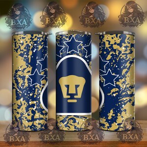 May include: A blue and gold tumbler with a white outline of a puma head and five stars. The background is a blue and gold splatter pattern.