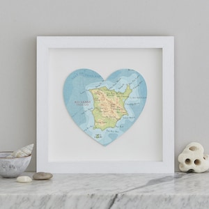 Könnte beinhalten: Ein weiß gerahmter Druck einer herzförmigen Karte von Ko Samui, Thailand. Die Karte ist in einem hellblauen Farbschema mit braunen Linien und Text gehalten. Der Text auf der Karte enthält "Ko Samui, Thailand" und "Golf von Thailand".