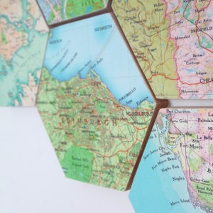 May include: Hexagon-shaped map tiles featuring detailed cartography of various locations. The tiles are arranged together, showcasing a collage of different areas. The maps have a vintage aesthetic with a mix of colors.