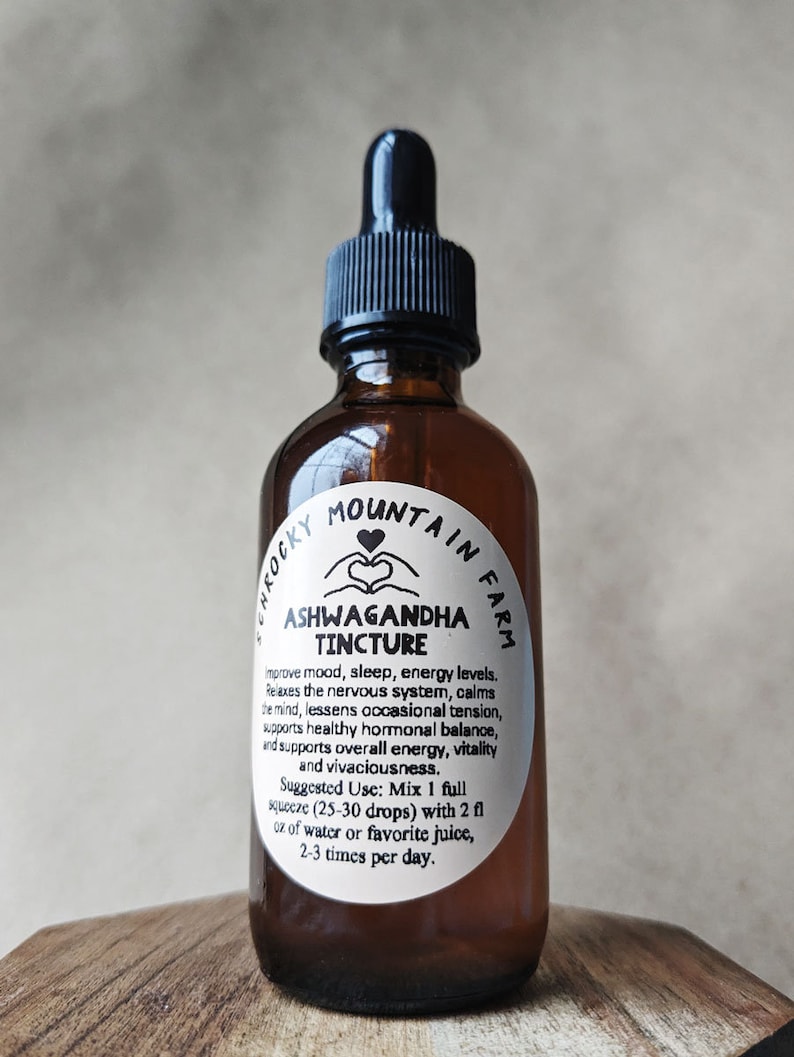 May include: A brown glass bottle with a dropper top and a white label that reads "Rocky Mountain Farm Ashwagandha Tincture". The label also includes instructions for use: "Improve mood, sleep, energy levels. Relaxes the nervous system, calms the mind, lessens occasional tension, supports healthy hormonal balance, and supports overall energy, vitality and vivaciousness. Suggested Use: Mix 1 full squeeze (25-30 drops) with 2 fl oz of water or favorite juice, 2-3 times per day."