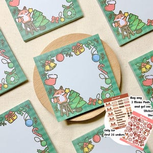 May include: Set of four green and white Christmas themed memo pads with a fox decorating a Christmas tree. Each pad has a blank space for writing notes. The set also includes a sticker sheet with a fox and Christmas tree design and a journal sticker sheet with a fox and days of the week.