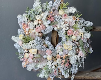 Kerstkrans voor de voordeur, pastelkleurige winterkrans, handgemaakte, ijzige feestdecoratie met rozen en ornamenten.