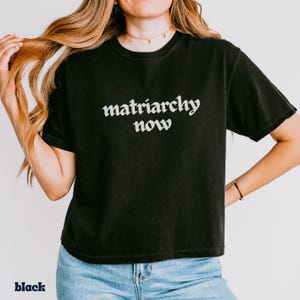 Fashion Forward Feminist Tee Shirt Statement Piece Design Equality Message Apparel Womens Rights Movement Cotton Fabric Boxy Fit Vintage Look Bold Graphic Design Conversation Starter Everyday Wear Progressive Fashion Social Statement