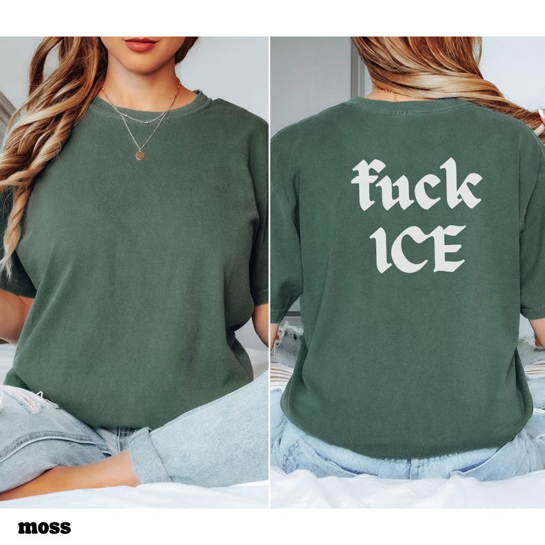 May include: Moss green t-shirt with the text "fuck ICE" in white gothic font on the back. The front of the shirt is plain. The shirt is made of a soft material.