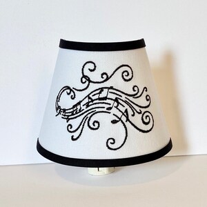 May include: A white lampshade with a black trim and a black musical note design.