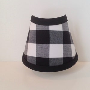 May include: Black and white buffalo plaid lampshade with a black trim.
