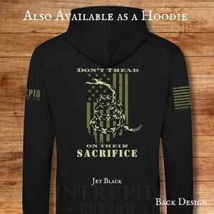 May include: Jet black hoodie with a back design featuring a coiled snake over a striped flag, with the words "DON'T TREAD" and "ON THEIR SACRIFICE". The text "ALSO AVAILABLE AS A HOODIE" is at the top.