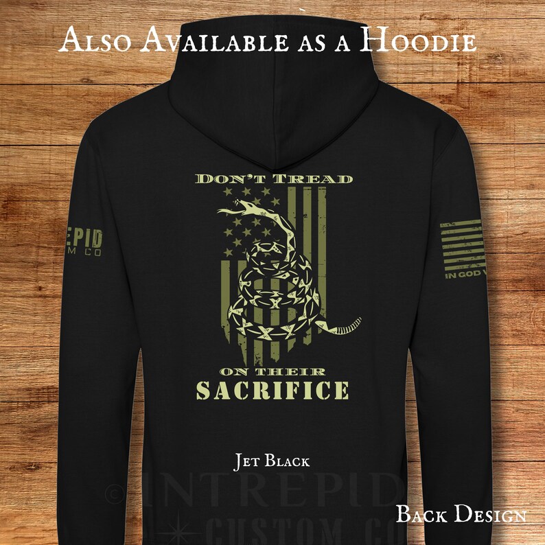May include: Jet black hoodie with a back design featuring a coiled snake over a striped flag, with the words "DON'T TREAD" and "ON THEIR SACRIFICE". The text "ALSO AVAILABLE AS A HOODIE" is at the top.