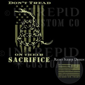 May include: Black graphic design featuring a coiled rattlesnake over a distressed American flag. Text reads "DON'T TREAD ON THEIR SACRIFICE" and "IN GOD WE TRUST". A right sleeve design is also shown.