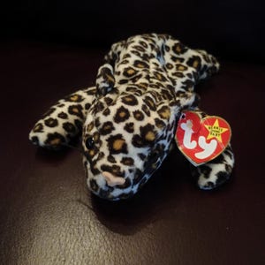 Op de afbeelding: Een bruin en wit luipaardprint beanie baby pluche speelgoed met een rood Ty-label met de tekst "Beanie Baby".