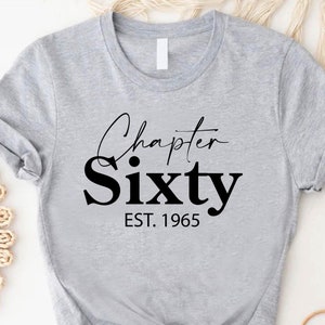 May include: Gray t-shirt with black text that reads "Chapter Sixty EST. 1965".