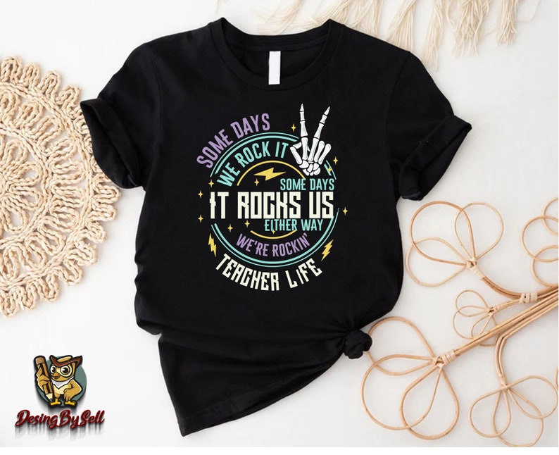 a black t - shirt with a rock and roll design on it