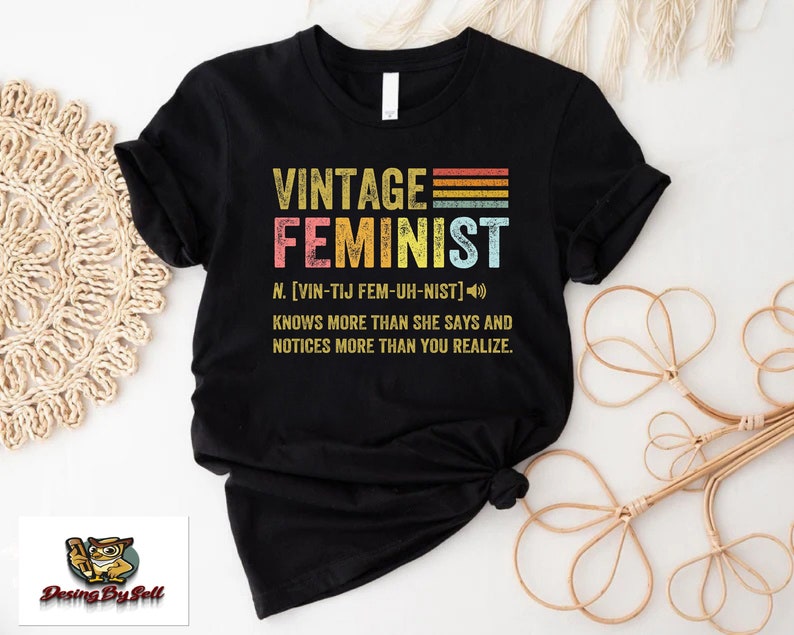 a vintage feminist t - shirt sitting on top of a table