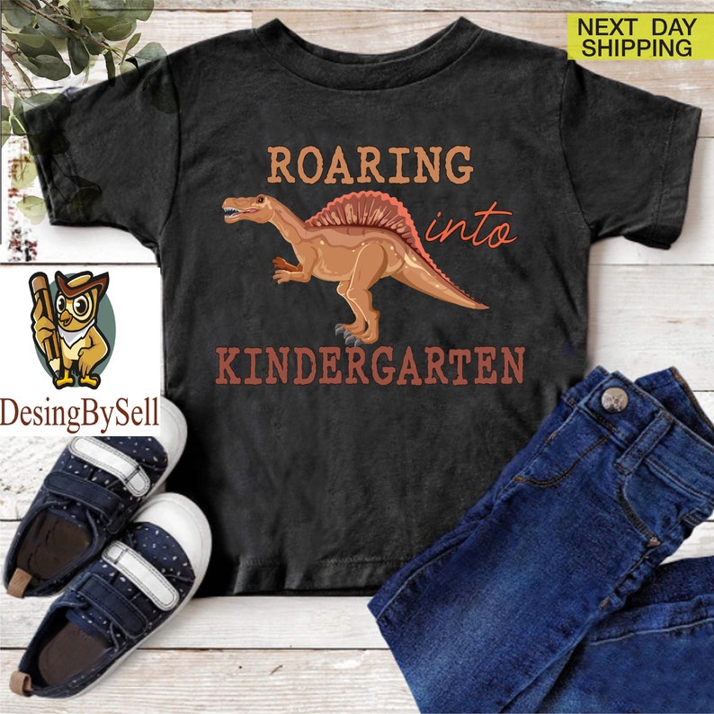 a t - shirt with a dinosaur on it and a pair of jeans