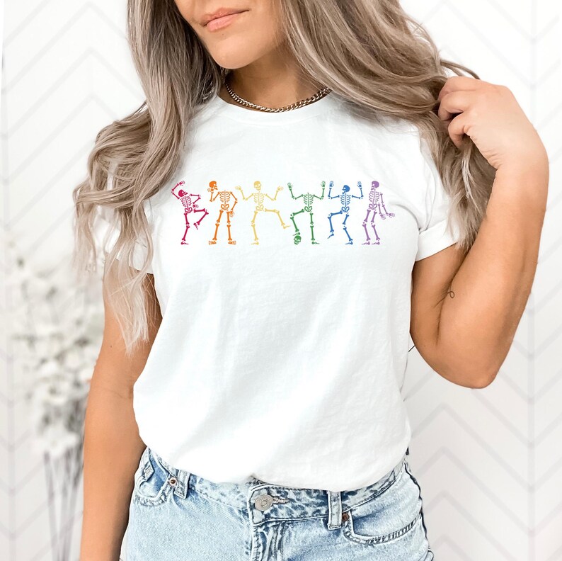 a woman wearing a white t - shirt with colorful figures on it