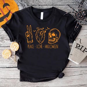 a black t - shirt with the words peace love halloween on it