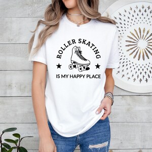 May include: White t-shirt with a black graphic of a roller skate and the text "ROLLER SKATING IS MY HAPPY PLACE". The shirt is made of a soft material and is suitable for casual wear.