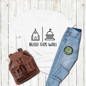 a t - shirt that says build this world next to a pair of jeans