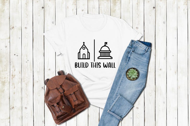 a t - shirt that says build this world next to a pair of jeans