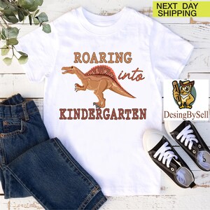 a t - shirt with a dinosaur on it and a pair of jeans