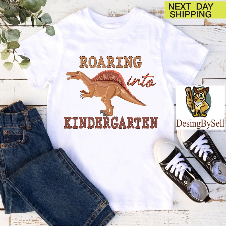 a t - shirt with a dinosaur on it and a pair of jeans
