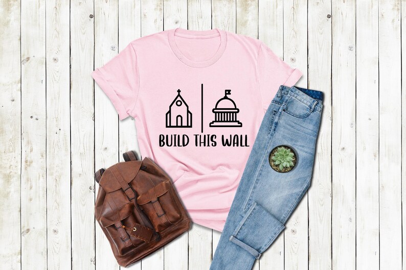 a t - shirt that says build this wall next to a pair of jeans