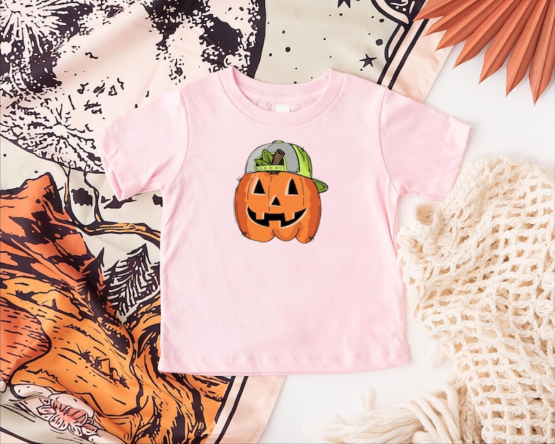 a pink shirt with a pumpkin on it